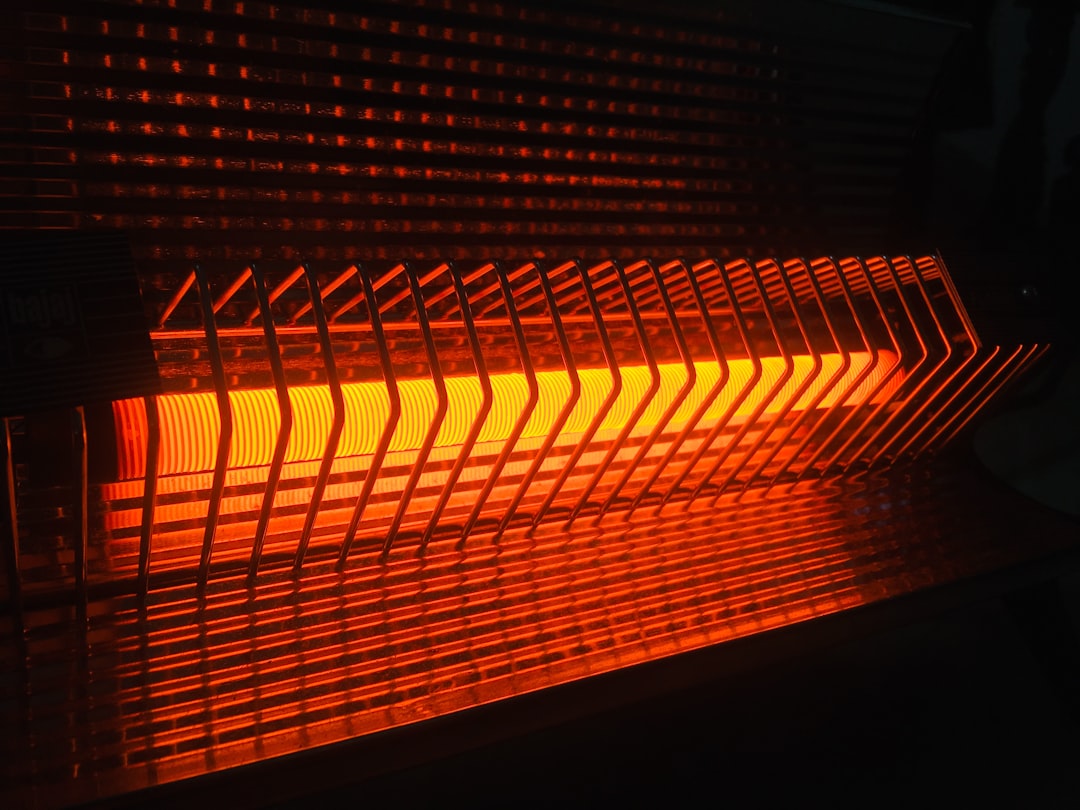 A residential heating unit with a glowing hot surface igniter element inside the burner compartment